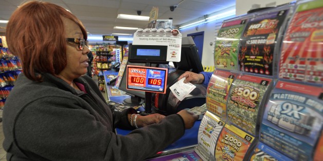 In this Oct. 23, 2015 photo, Vera Washington of Chicago, buys lotto tickets at the K&D Marathon station in Hammond, Ind. With Illinois delaying payouts over $600 because of its budget mess, neighboring states are salivating at the chance to boost sales. Businesses near borders, particularly in Indiana, Kentucky and Iowa, say theyâve already noticed a difference. The Lottery problems stemming from Illinoisâ budget impasse have led to a lawsuit and come amid questions about Illinois reve