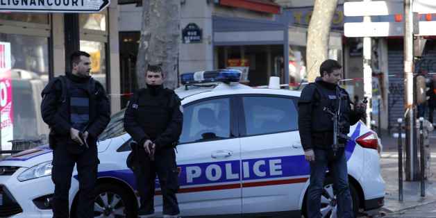 A police officer guards the police station, seen in background, after officers shot and killed a knife-wielding man wearing a fake explosives vest, in Paris, Thursday, Jan. 7, 2016. Officers shot and killed a knife-wielding man wearing a fake explosive vest at a police station in northern Paris on Thursday, French officials said, a year to the day after an attack on the French satirical newspaper Charlie Hebdo launched a bloody year in the French capital. (AP Photo/Michel Euler)