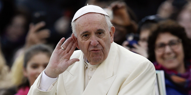 Pope Francis puts his hand to his ear to listen to a musical band playing as he arrives on his popemobile in St. Peter's Square for the weekly general audience, at the Vatican, Wednesday, Dec. 9, 2015. (AP Photo/Gregorio Borgia)