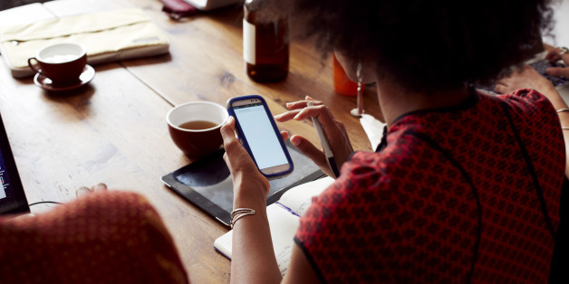 Businesswoman using cell phone in cafe