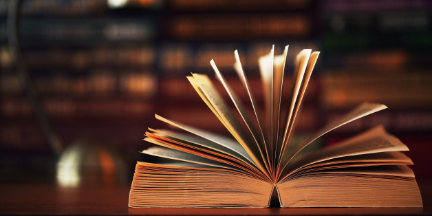 Beautiful open book laying on a table. Golden tones. Vibrant color.