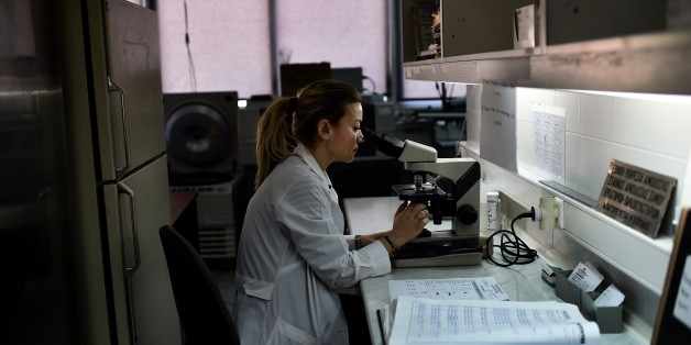 TO GO WITH AFP STORY BY SOPHIE MAKRIS A doctor looks through a microscope at a hospital on the eastern Greek island of Samos on January 20, 2015. Greece's economic woes mean that paramedics on the picturesque island of Samos are increasingly faced with the terrible dilemma of who to save and who to leave to die. On January 25, Greeks vote in a general election for the second time in three years, with radical leftists Syriza leading the polls with a promise to renegotiate the international bailout that has imposed five years of austerity on the country. AFP PHOTO / ARIS MESSINIS (Photo credit should read ARIS MESSINIS/AFP/Getty Images)
