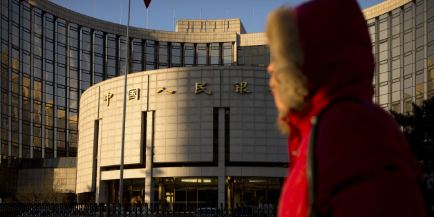 In this Friday, Jan. 8, 2016 photo, a woman walks past China's central bank, the People's Bank of China, in Beijing. Stock market and currency turmoil has battered Chinese leadersâ reputation as shrewd economic managers and fed doubts about their ability and willingness to push more wrenching reforms. (AP Photo/Mark Schiefelbein)