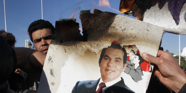 FILE - In this Monday, Jan. 24, 2011 picture, protestors burn a photo of former President Zine El Abidine Ben Ali during a demonstration in Tunis, Tunisia against holdovers from Ben Ali's regime in the interim government. In late January 2011, Tunisians have a chance to do what was undreamable weeks earlier: Build a democracy from the ground up. This Arab nation of 11 million has started a revolution against longtime authoritarian regimes that has already spread to the powerful regional giant, Egypt, and to the impoverished but well-armed Yemen. What is not clear is where Tunisia's experiment will end. (AP Photo/Christophe Ena)