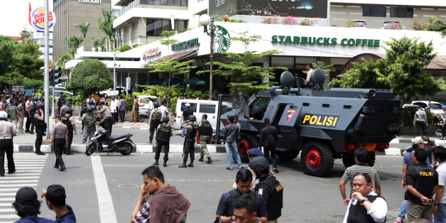 Police officers stand guard outside a Starbucks cafe near where an explosion went off in Jakarta, Indonesia Thursday, Jan. 14, 2016. Attackers set off explosions at a Starbucks cafe in a bustling shopping area of downtown Jakarta and waged gun-battles with police Thursday, leaving bodies in the streets as office workers watched in terror from high-rise windows. (AP Photo/Achmad Ibrahim)