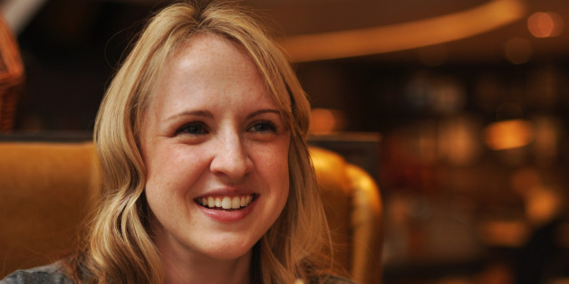 Blonde smiling woman setting in restaurant.
