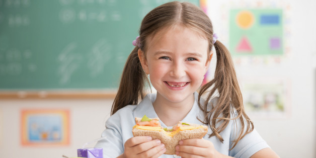 Caucasian student eating lunch in classroom