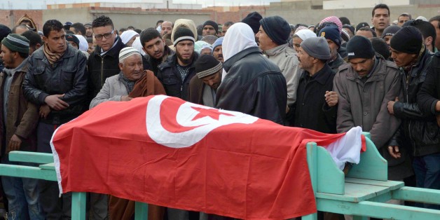 Mourners carry the coffin wrapped by the Tunisian flag of one of the four national guards killed in an ambush during a funeral procession in Kasserine, Tunisia, Wednesday, Feb. 18, 2015. Radical militants killed four members of the National Guard in the mountainous Kasserine region near the Algerian border, Tunisia's Interior Ministry said early Wednesday. The brief statement blamed "terrorists" for the attack but gave no other details. Local radio added that the attack took place around midnigh