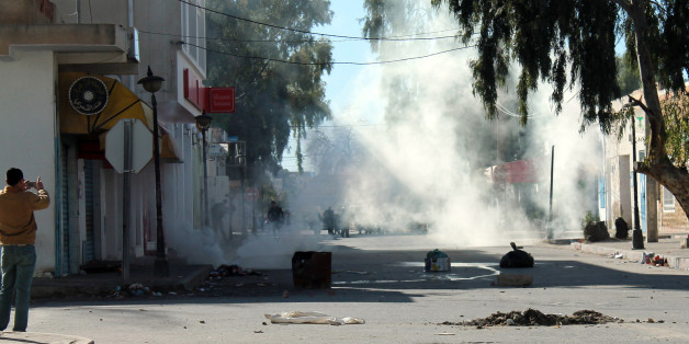 Tunisian protesters take the streets in the southern town of Kasserine , Tunisia, and clash with riot police during a protest against a new tax on vehicles, Wednesday, Jan. 8, 2014. Protesters called the government the "assassin of our dreams," complaining that little has changed since the country's reviled leader was ousted in 2011. (AP Photo/Mouldi Kraiem)