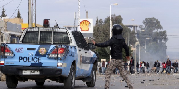 Protesters face police forces in the city of Ennour, near Kasserine, Tunisia, Wednesday, Jan. 20, 2016. Tunisia has declared a curfew in the western city after clashes between police and more than 1,000 young protesters demonstrating for jobs. Tensions have risen in Kasserine since Sunday when an unemployed youth killed himself by scaling an electricity transmission tower to protest his rejection for a government job. (AP Photo/Moncef Tajouri)