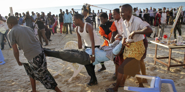 Relatives carry away a dead body from the beach following an overnight attack on a beachfront restaurant in Mogadishu, Somalia, Friday, Jan. 22, 2016. Somalia's security forces ended a deadly siege of a beachfront restaurant in the capital, with many killed in the attack, a police official said Friday. (AP Photo/Farah Abdi Warsameh)
