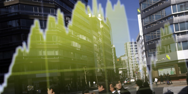 Pedestrians are reflected on an electronic stock board at a securities firm in Tokyo, Friday, Jan. 22, 2016. Asian stocks rallied Friday, extending a global market rebound fueled by the prospect of more stimulus from European policymakers and a bounce in oil prices. (AP Photo/Eugene Hoshiko)