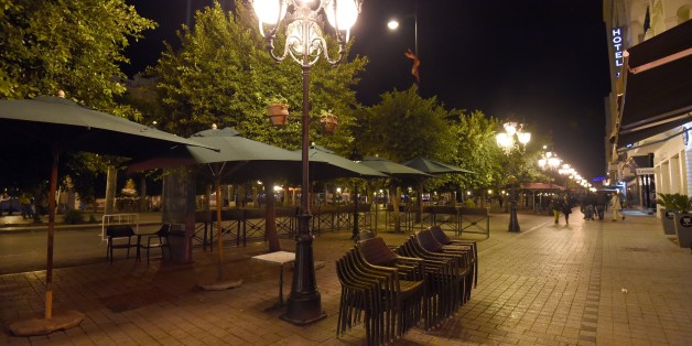 TO GO WITH AFP STORY BY KAOUTHER LARBIA picture taken on November 26, 2015 early in the evening shows closed restaurants on Habib Bourguiba Avenue in the centre of Tunis due to a curfew put in place since the attack against the bus transporting guards from the presidential security that killed 12 people. After nine o'clock in the evening only the Tunisian police can be seen in the deserted streets of the capital since the curfew was put in place. AFP PHOTO / FETHI BELAID / AFP / FETHI BELAID