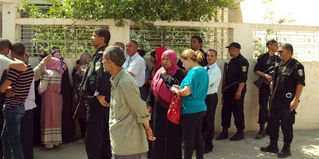 Bystanders gather in front of Tunisian Interior Minister Lotfi Ben Jeddou's residence in Kasserine, southern Tunisia, after gunmen attacked the home of the country's top security official killing four of the policeman standing guard outside, Wednesday, May 28, 2014. The attack on Interior Minister Lotfi Ben Jeddou's home in the southern city of Kasserine took place just before midnight and involved six or seven attackers. (AP Photo/Mouldi Kraiem)