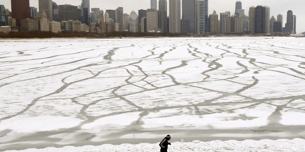 A lone jogger runs in the snow near the Adler Planetarium and Monroe Harbor on Lake Michigan Friday, Jan. 22, 2016, in Chicago. The Chicago area will dodge a major snowstorm where one in seven Americans will get at least half a foot of snow outside their homes when this weekend's big storm has finished delivering blizzards, gale-force winds, white-out conditions and flooding to much of the eastern United States. (AP Photo/Charles Rex Arbogast)