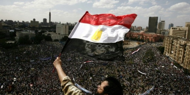 Un manifestant brandit le 8 avril 2011 un drapeau égyptien alors que des dizaines de milliers de personnes sont regroupées sur la place Tahrir, deux mois après la chute de Moubarak