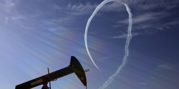 An oil pump stands as the Saudi Hawks Aerobatic Team of the Royal Saudi Air Force performs during the Bahrain International Airshow in Sakhir, Bahrain, Saturday, Jan. 23, 2016. (AP Photo/Hasan Jamali)