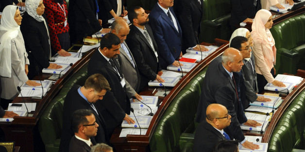 Tunisian parliament members take their oath of office on the Quran during the inaugural session of the newly elected Tunisian parliament in Tunis, Tuesday, Dec. 2, 2014. This is the first national assembly meeting since the October 2014 legislative elections that resulted in a victory for opposition secular parties. (AP Photo/Hassene Dridi)