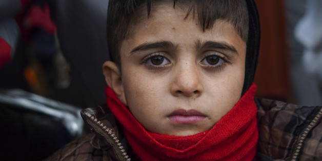 A boy who just arrived on a dinghy with other migrants and refugees from the Turkish coast to the Greek island of Lesbos, looks on, Tuesday, Jan. 26, 2016. More than 850,000 people, most fleeing conflict in Syria and Afghanistan, entered Greece by sea in 2015, according to the UNHCR, and already in 2016, some 35,455 people have arrived despite plunging winter temperatures. (AP Photo/Mstyslav Chernov)