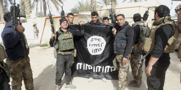 In this Tuesday, Jan. 19, 2016 photo, Iraqi security forces celebrate as they hold a flag of the Islamic State group, in Ramadi, 70 miles (115 kilometers) west of Baghdad, Iraq. The Islamic State group, which controls large parts of Syria and Iraq where it declared an Islamic caliphate in June 2014, suffered several defeats recently in both countries, including the loss of the Iraqi city of Ramadi and parts of northern and northeastern Syria over the past months. (AP Photo)