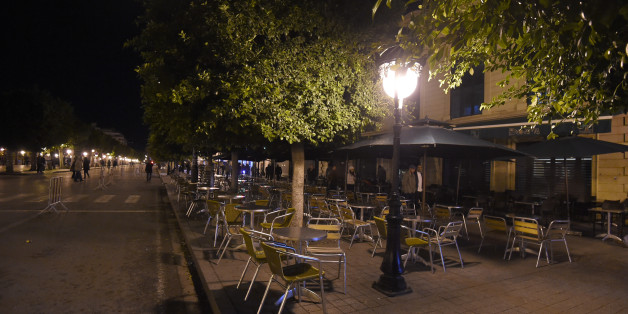 TO GO WITH AFP STORY BY KAOUTHER LARBI
A picture taken on November 26, 2015 early in the evening shows closed restaurants on Habib Bourguiba Avenue in the centre of Tunis due to a curfew put in place since the attack against the bus transporting guards from the presidential security that killed 12 people. After nine o'clock in the evening only the Tunisian police can be seen in the deserted streets of the capital since the curfew was put in place. AFP PHOTO / FETHI BELAID / AFP / FETHI BELAID (Photo credit should read FETHI BELAID/AFP/Getty Images)