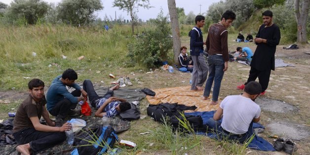 Refugees from Afghanistan gather in no man's land between an old, partly ruined brick factory and a dump on the outskirts of Subotica, northern Serbia, near the Hungarian border, Monday, June 29, 2015. Illegal migrants usually wait here until they can cross the border into Hungary and the Schengen zone of the European Union. (Edvard Molnar/MTI via AP)