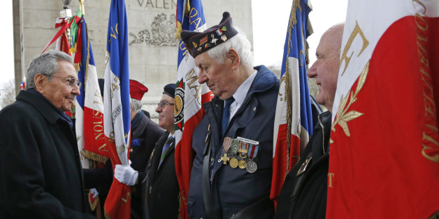 Cuba's President Raul Castro, left, shakes hands with war veterans during a ceremony at the Tomb of the Unknown Soldier at the Arc de Triomphe in Paris, Monday, Feb. 1, 2016. Raul Castro is paying a state visit to France, in the first European foray by a Cuban leader in two decades, as Cuba opens up its economy. (Jacky Naegelen/Pool photo via AP)