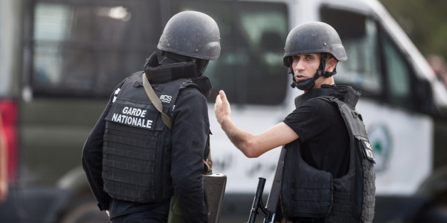 Members of the Tunisian National Guard take positions as they secure the scene of a shooting in the Oued Ellil suburb of Tunis, Tunisia, Thursday, Oct. 23, 2014. A Tunisia official says a security officer has been killed in a shootout that began when a suspect's home was surrounded near the capital. Interior Ministry spokesman Mohammed Ali Aroui says the exchange of fire Thursday came after a pair of counterterrorism operations in the south that left one bystander dead. (AP Photo/Aimen Zine)