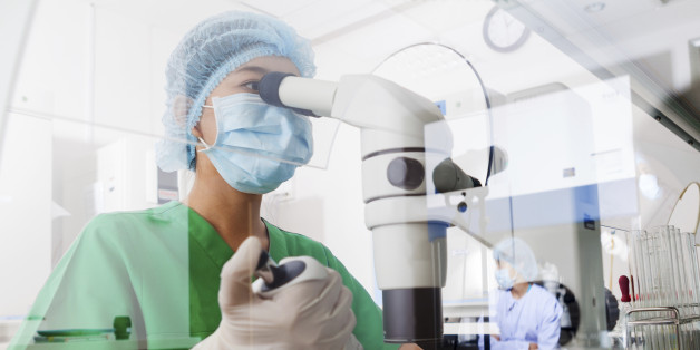 Asian scientist using microscope in the laboratory