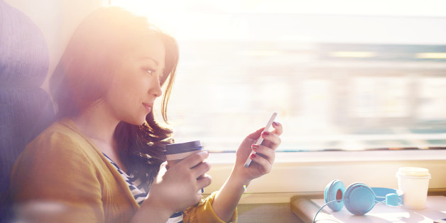 Woman on a commuter train looking at her phone.