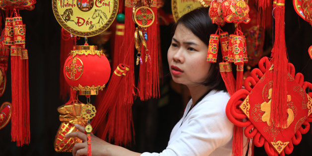 A woman looks at Lunar New Year decorations in the old quarter of Hanoi, Vietnam on Saturday, Feb. 6, 2016. Vietnam will celebrate Lunar New Year, known locally as Tet, on Monday, Feb. 8. (AP Photo/Hau Dinh)