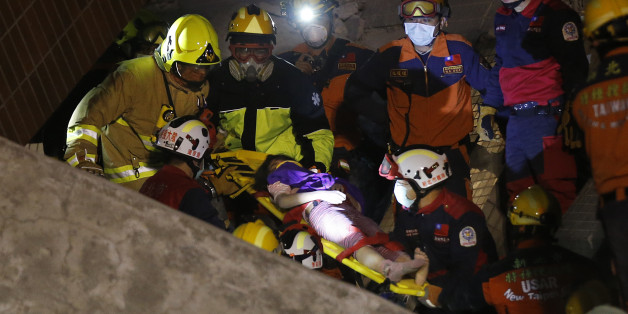 A female is rescued from a collapsed building complex after an early morning earthquake in Tainan, Taiwan, Saturday, Feb. 6, 2016. A 6.4-magnitude earthquake struck southern Taiwan early Saturday, toppling at least one high-rise residential building and trapping people inside. (AP Photo/Wally Santana)