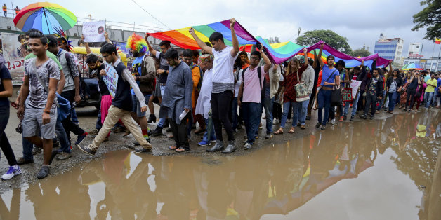 Members and supporters of lesbian, gay, bisexual and transgender community, hold a large rainbow flag as they walk past a puddle of rain water during a 'Pride March' rally in Bangalore, India, Sunday, Nov. 22, 2015. Gay rights supporters waved flags and danced past traffic during the march to celebrate gay pride and to push for the repeal of a colonial-era law that makes homosexuality a crime. (AP Photo/Aijaz Rahi)