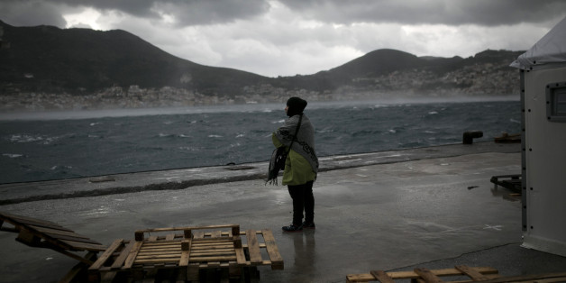 A migrant stands in front of a tent of the UNHCR at the registration center on the Greek island of Samos on January 17, 2016. / AFP / ANGELOS TZORTZINIS (Photo credit should read ANGELOS TZORTZINIS/AFP/Getty Images)