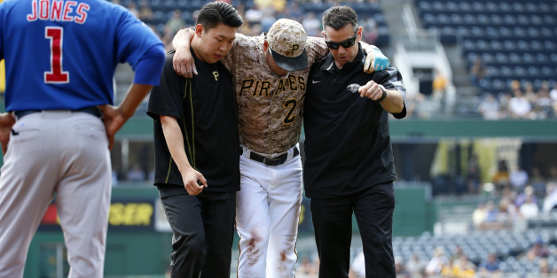 Pittsburgh Pirates' Jung Ho Kang, center, is helped off the field by team trainer, right, and his interpreter after injuring his left leg turning a double play in the first inning of a baseball game against the Chicago Cubs in Pittsburgh, Thursday, Sept. 17, 2015. Kang left the game. (AP Photo/Gene J. Puskar)