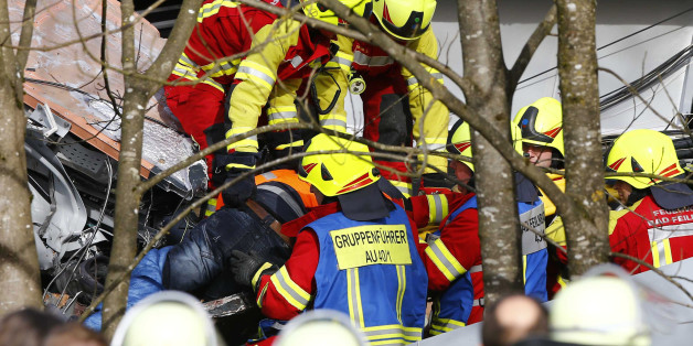 Rescue workers salvage a body at the site where two trains collided head-on near Bad Aibling, southern Germany, Tuesday, Feb. 9, 2016. Several people have been killed and dozens were injured. (AP Photo/Matthias Schrader)