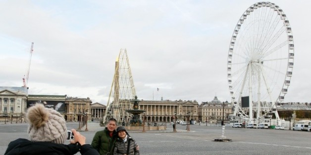 Des touristes prennent la pose devant la place de la Concorde à Paris le 30 novembre 2015