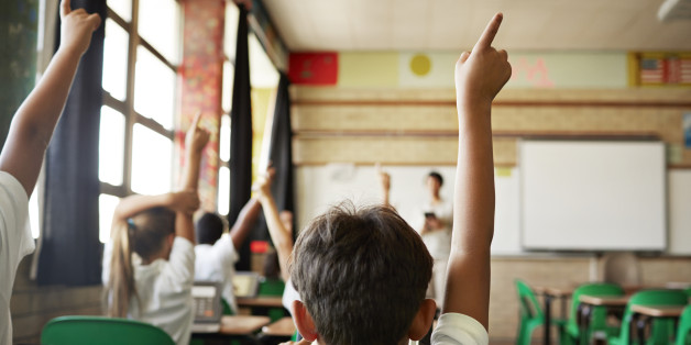 School children in uniforms in class with tablets