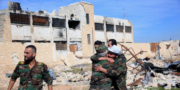 In this photo released by the Syrian official news agency SANA, shows Syrian government troops hug each other in celebration inside the Kweiras air base, east of Aleppo, Syria, Wednesday, Nov. 11, 2015. Syrian government forces broke a siege imposed by the Islamic State group on the northern military air base of Kweiras since 2013. The international community is mounting its most serious effort yet to end the nearly five-year-old Syrian war, rallying around a second round of talks in Vienna this