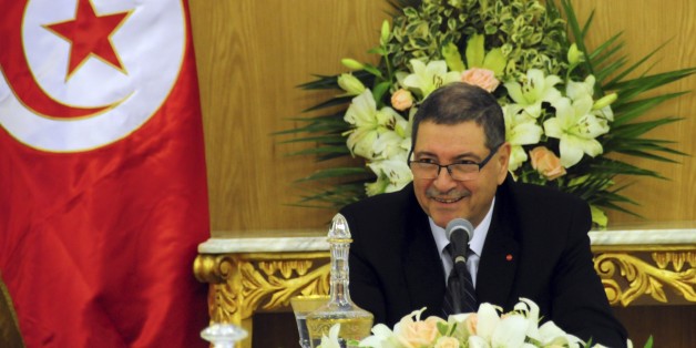 Tunisia's Prime Minister Habib Essid shares a smile with ministers prior to preside over an extraordinary Cabinet meeting in Carthage, outside Tunis, Saturday Jan. 23, 2016. Tunisia's prime minister, Habib Essid, cut short a visit to France as Tunisia's president vowed Friday to end the cycle of unrest that has pummeled towns across the country as authorities imposed a nationwide curfew, five years after the nation, convulsed by protests, overthrew its longtime ruler and moved onto the road to d