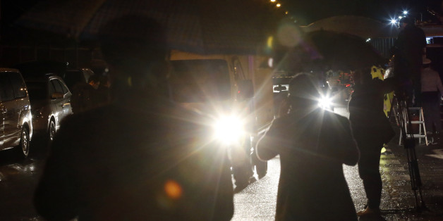 South Koreans holding umbrellas wait for their companies' vehicles returning from North Korea's joint Kaesong Industrial Complex after crossing the Unification Bridge, near the border village of Panmunjom in Paju, South Korea, Thursday, Feb. 11, 2016. North Korea on Thursday ordered a military takeover of a factory park that had been the last major symbol of cooperation with South Korea, calling Seoul's earlier suspension of operations at the jointly run facility as punishment for the North's re