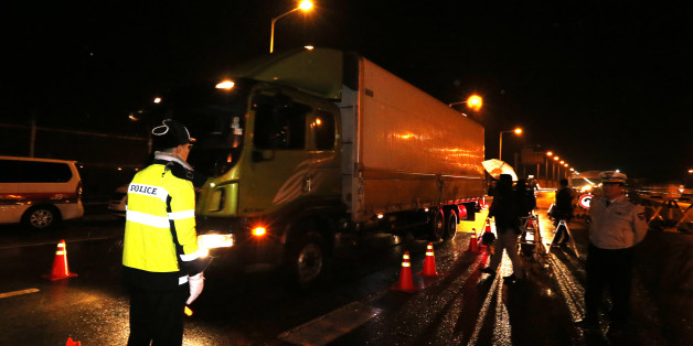South Korean police officers direct traffic upon South Korean vehicles returning from North Korea's joint Kaesong Industrial Complex after crossing the Unification Bridge, near the border village of Panmunjom in Paju, South Korea, Thursday, Feb. 11, 2016. North Korea on Thursday ordered a military takeover of a factory park that had been the last major symbol of cooperation with South Korea, calling Seoul's earlier suspension of operations at the jointly run facility as punishment for the North'