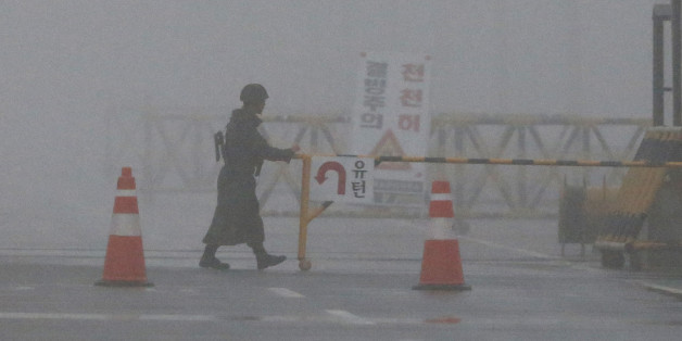 A South Korean Army soldier adjusts barricade on a foggy and rainy morning at Unification Bridge near the border village of Panmunjom in Paju, South Korea, Friday, Feb. 12, 2016. North Korea on Thursday ordered a military takeover of a factory park that had been the last major symbol of cooperation with South Korea, calling Seoul's earlier suspension of operations at the jointly run facility as punishment for the North's recent rocket launch a "dangerous declaration of war." (AP Photo/Lee Jin-man)
