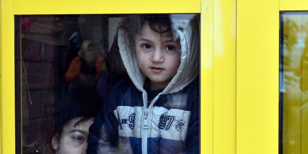 Children peer from passenger's terminal in the port of Piraeus upon his arrival with other migrants and refugees from the island of Lesbos on February 10, 2016.
EU migration commissioner Dimitris Avramopoulos said on February 10, 2016 he has written letters to member states with a 'clear and strong message' to accelerate the relocation of refugees from overstretched Greece and Italy. Streams of people fleeing conflict or poverty continue to make the often perilous journey from Turkey across the Mediterranean and through the Balkans, despite cold winter weather, in the hope of starting new lives in more prosperous European countries. / AFP / LOUISA GOULIAMAKI (Photo credit should read LOUISA GOULIAMAKI/AFP/Getty Images)