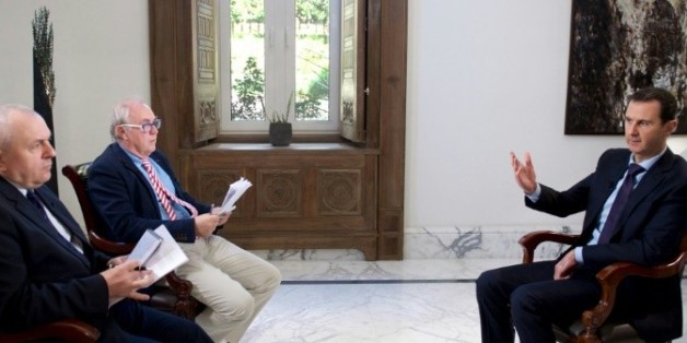 Une photo fournie par le service de presse de la présidence syrienne, montre Bachar al-Assad avec les deux journalistes de l'AFP, Christian Chaise (G) et Sammy Ketz (2ème), le 11 février 2016 à Damas