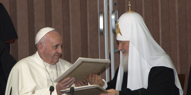 Pope Francis, left, and Russian Orthodox Patriarch Kirill exchange documents during their historic meeting in Havana, Cuba, Friday, Feb. 12, 2016. Francis and Kirill signed a joint declaration on religious unity. The declaration calls for peace in Syria, Iraq and Ukraine and urges Europe to "maintain its faithfulness to its Christian roots." (Ismael Francisco/Cubadebate via AP)