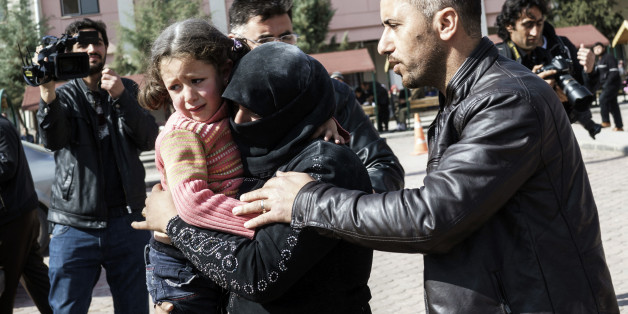 A Turkish man helps a Syrian woman carrying a wounded Syrian girl to a hospital in Kilis, Turkey, Monday, Feb. 15, 2016. An airstrike in the northern Syrian province of Idlib destroyed a makeshift clinic supported by an international aid group on Monday, killing and wounding several people, activists and the group said. Doctors Without Borders, also known by its French acronym MSF, said in a statement that the hospital was hit with four times in two series of at least two attacks. It said the at