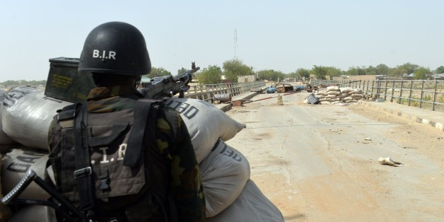 A picture taken on February 17, 2015 shows a Cameroonian soldier standing post in the Cameroonian town of Fotokol, on the border with Nigeria, after clashes occurred on February 4 between Cameroonian troops and Nigeria-based Boko Haram insurgents. Nigerian Boko Haram fighters went on the rampage in the Cameroonian border town of Fotokol on February 4, massacring dozens of civilians and torching a mosque before being repelled by regional forces AFP PHOTO / REINNIER KAZE