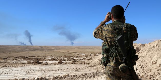 A member of a coalition force, which includes People's Protection Units (YPG) Women's Protection Units (YPJ), Sutoro militia, a pro-government Syriac Christian movement, and other forces, monitors the horizon in al-Hol in the Syrian Hasakeh province, some 650 kms northeast of Damascus, near the Iraqi border on November 2, 2015. AFP PHOTO / DELIL SOULEIMAN / AFP / DELIL SOULEIMAN (Photo credit should read DELIL SOULEIMAN/AFP/Getty Images)