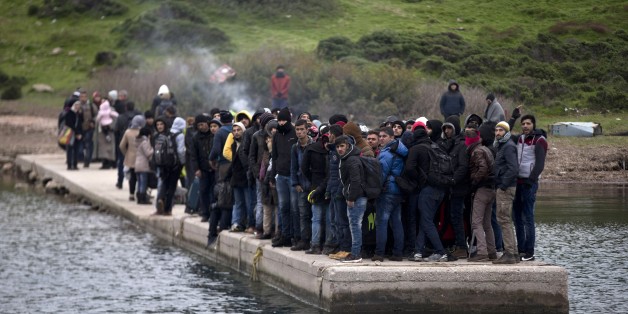 FILE - In this photo taken on Wednesday, Jan. 20, 2016, migrants who have arrived at the shore of the deserted Greek island of Pasas wait for the Coast Guard to transport them to Oinousses island. NATO's European commander on Thursday, Feb. 11, 2016, ordered three warships to move immediately to the Aegean Sea to help end the deadly smuggling of migrants between Turkey and Greece. (AP Photo/Petros Giannakouris, File)